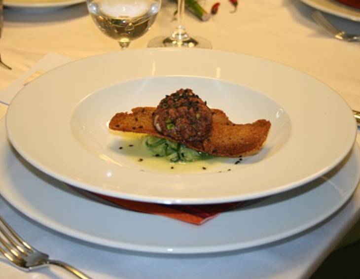 In Balsamico mariniertes Rinder Tartar mit Schwarzbrotchips und Dijonsenf-Gurken In Balsamico mariniertes Rinder Tartar mit Schwarzbrotchips und Dijonsenf-Gurken