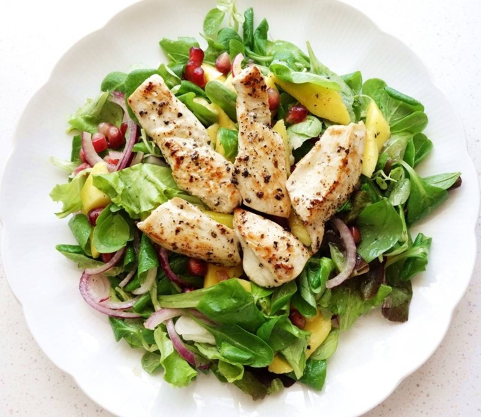 Putenstreifen auf Blattsalat mit Mango und Orangen-Senf-Dressing