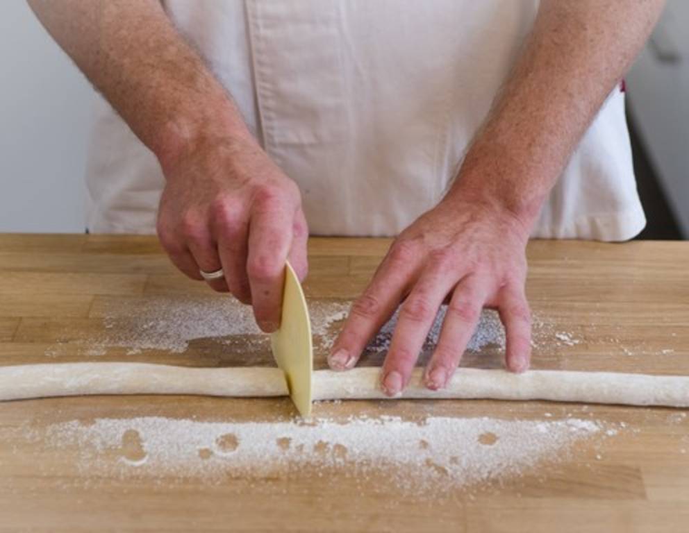 Schritt 12: Die Marzipanrolle in der Mitte auseinanderschneiden. Schritt 12: Die Marzipanrolle in der Mitte auseinanderschneiden.