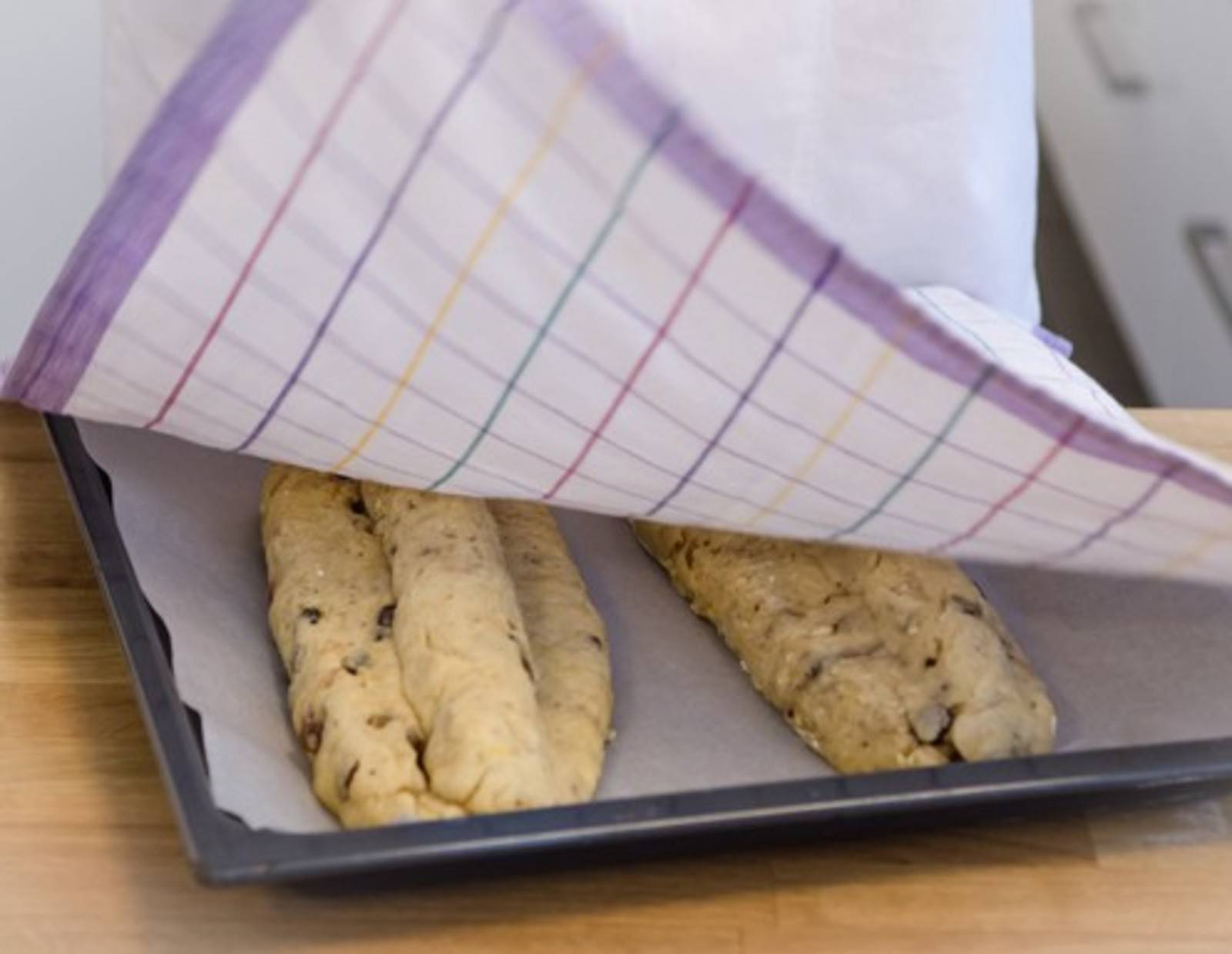 Schritt 38: Stollen auf ein Backblech legen und wiederum zugedeckt gehen lassen. Danach backen.