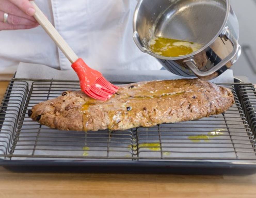 Schritt 39: Den gebackenen Stollen mit flüssiger Butter bestreichen. Schritt 39: Den gebackenen Stollen mit flüssiger Butter bestreichen.
