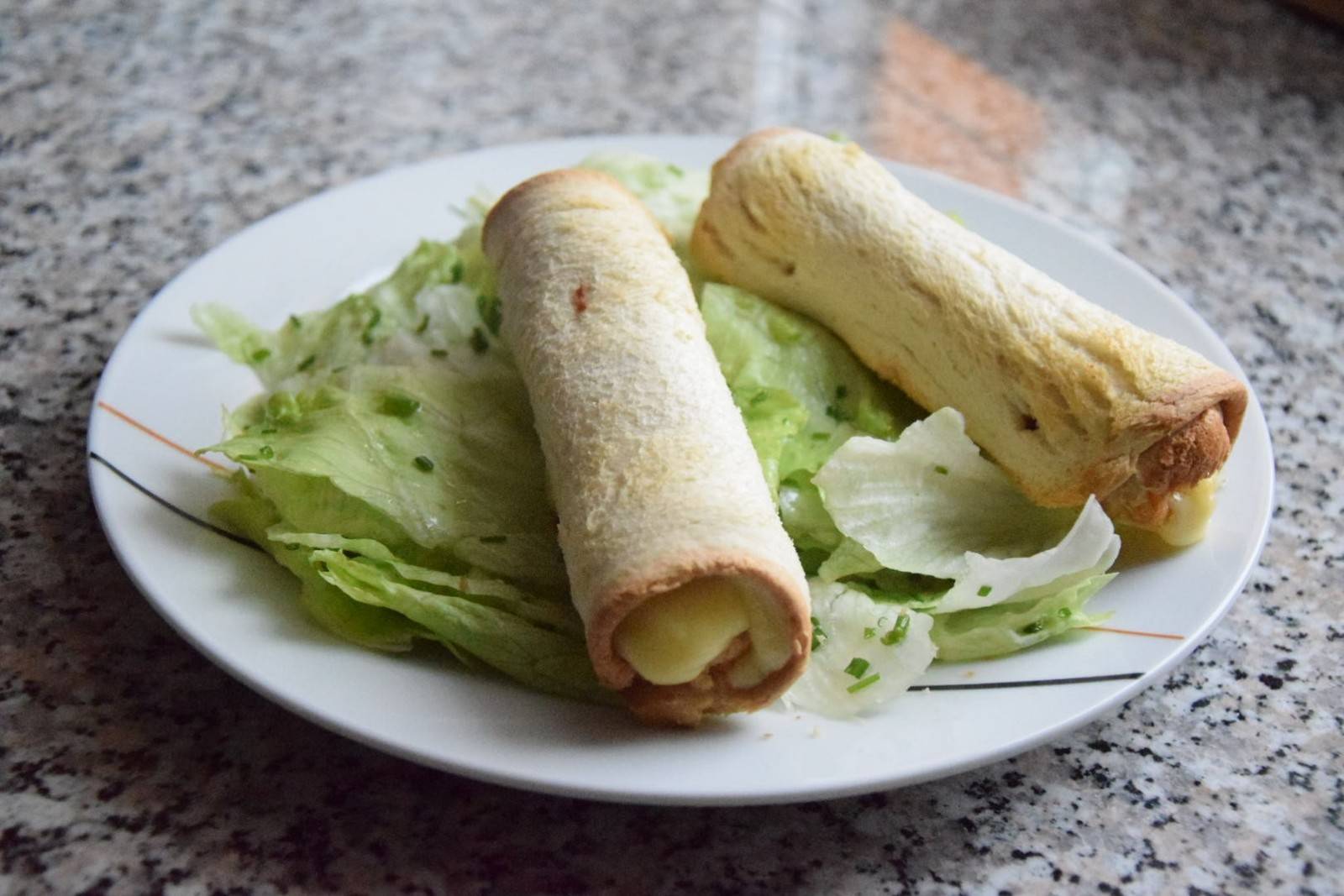 Toast-Röllchen auf grünem Salat