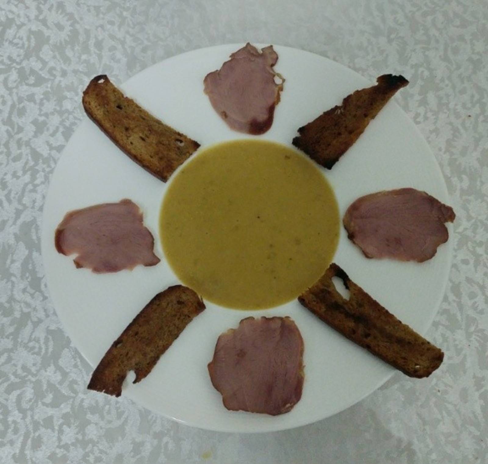 Erbsen Suppe mit geräucherter Entenbrust und Knoblauch Brot Chips