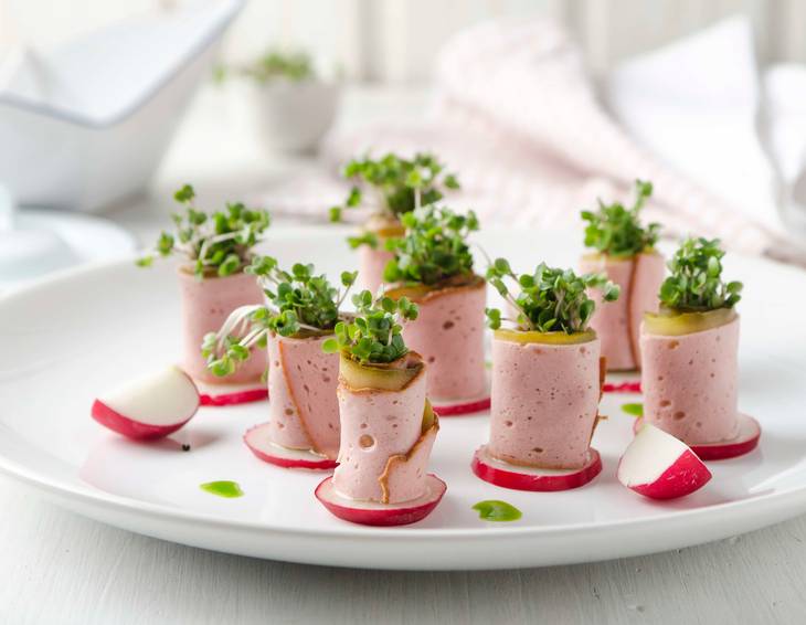Leberkäseröllchen mit Senfgurken, Radieschen und Blaukrautsprossen Leberkäseröllchen mit Senfgurken, Radieschen und Blaukrautsprossen
