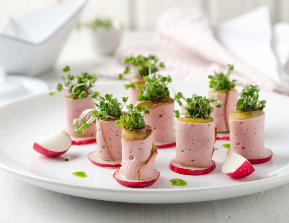 Leberkäseröllchen mit Senfgurken, Radieschen und Blaukrautsprossen Leberkäseröllchen mit Senfgurken, Radieschen und Blaukrautsprossen