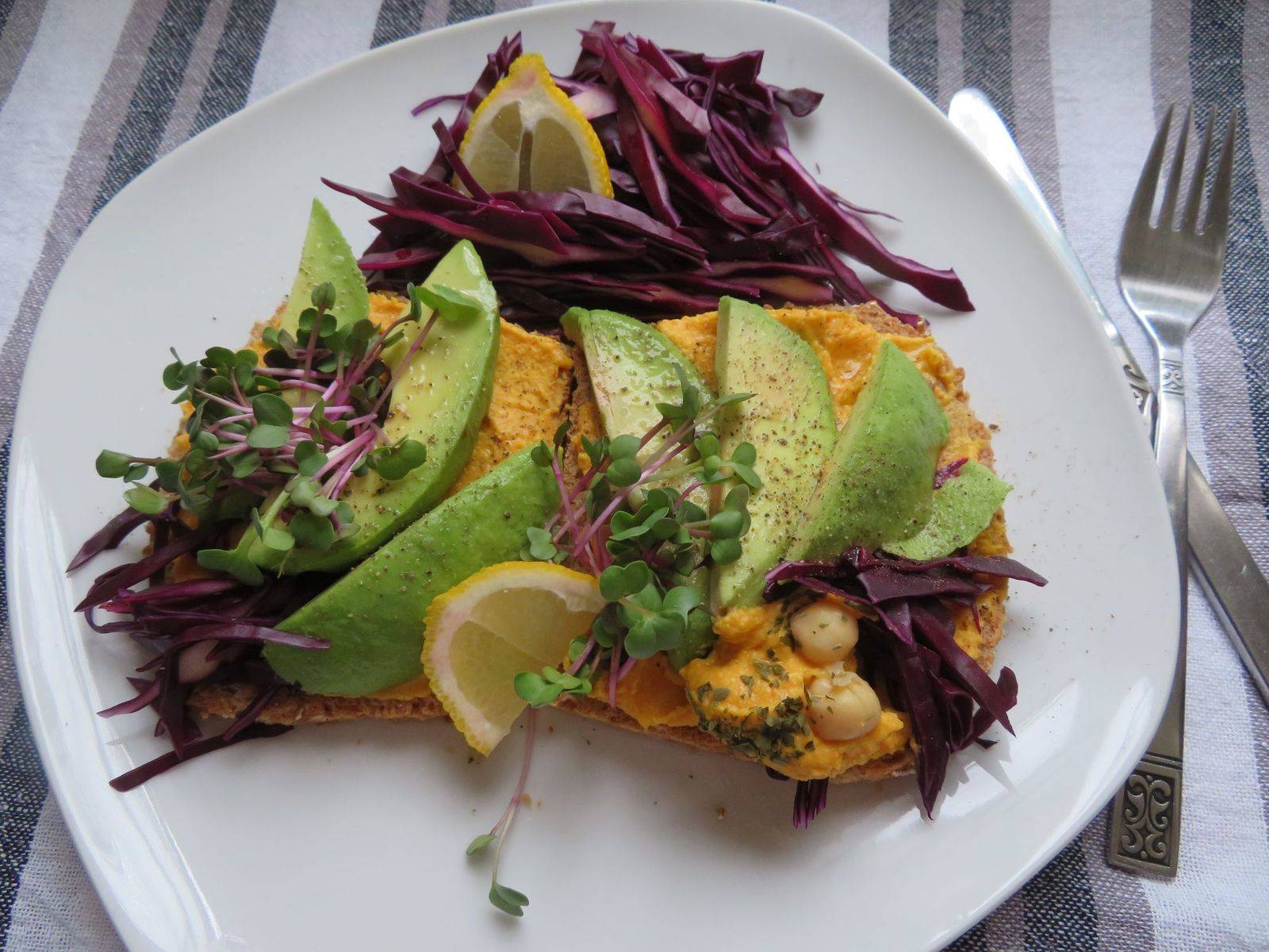Dinkelbrot mit Kürbis-Hummus, Avocado, Rotkraut und Radieschensprossen