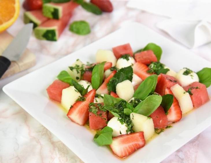 Obstsalat mit Erdbeeren, Melone und Mozzarella Obstsalat mit Erdbeeren, Melone und Mozzarella