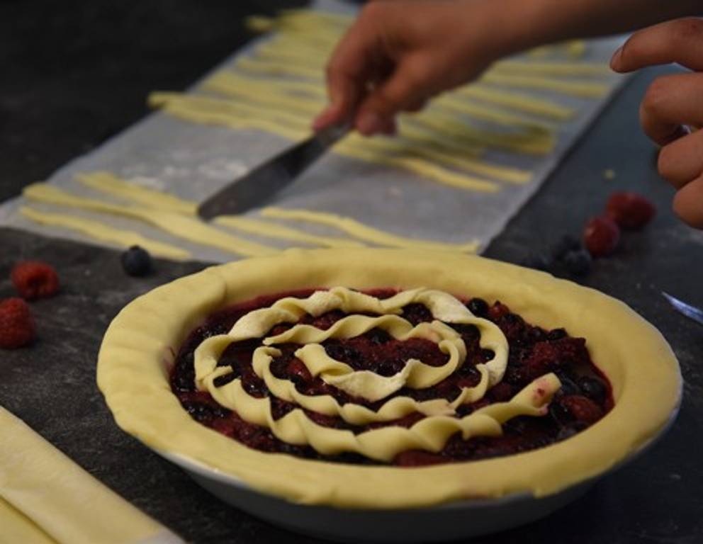 Der restliche Teig wird ausgerollt und in eher dünne Streifen geschnitten. Anschließend werden die Teigstreifen einzeln zu Spiralen eingedreht und kreisförmig auf der Füllmasse aufgelegt. Der restliche Teig wird ausgerollt und in eher dünne Streifen geschnitten. Anschließend werden die Teigstreifen einzeln zu Spiralen eingedreht und kreisförmig auf der Füllmasse aufgelegt.
