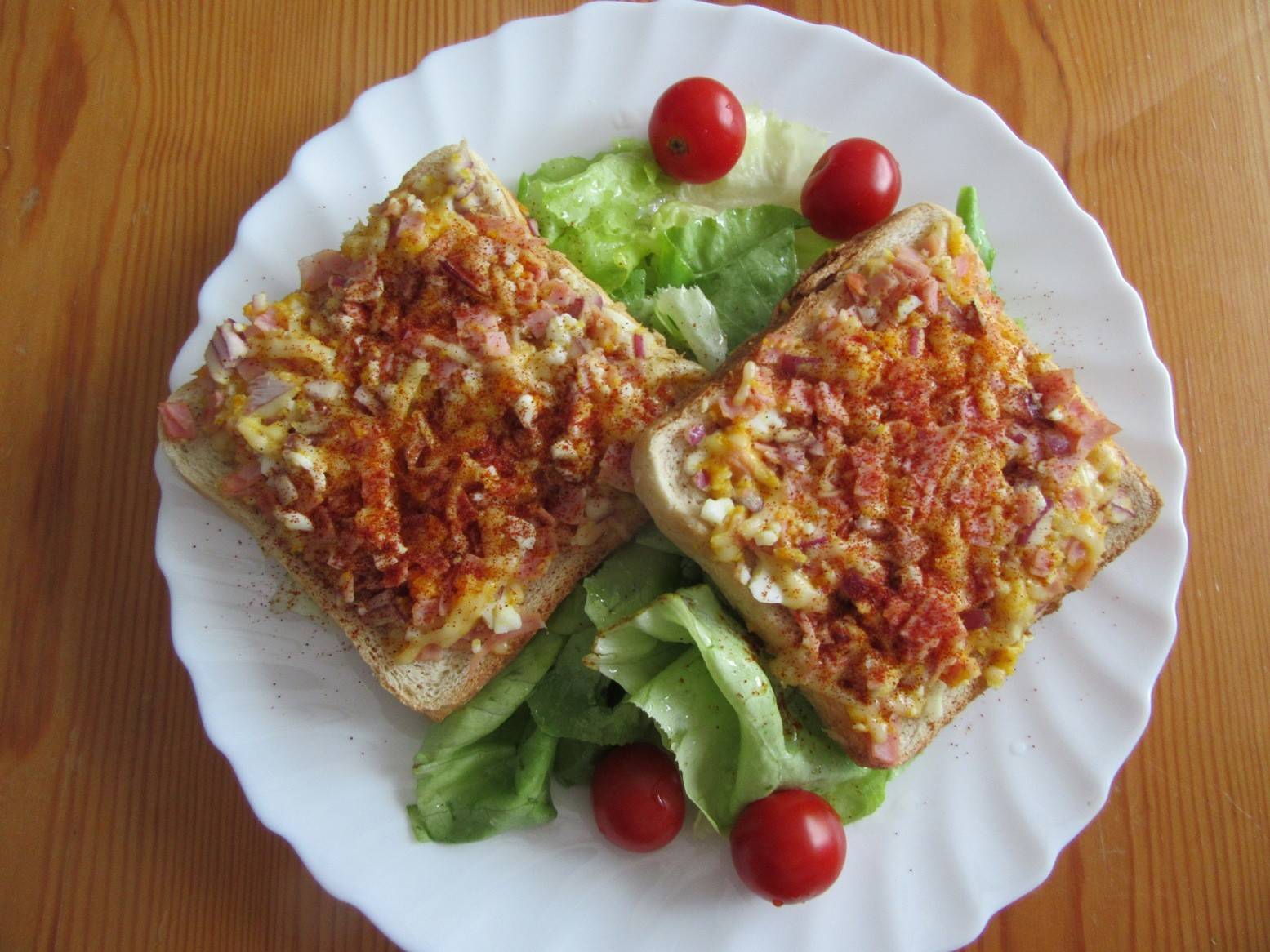 Toasts mit Schinken, Käse und Ei auf Blattsalat