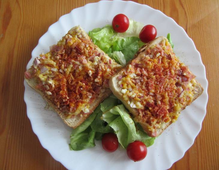 Toasts mit Schinken, Käse und Ei auf Blattsalat