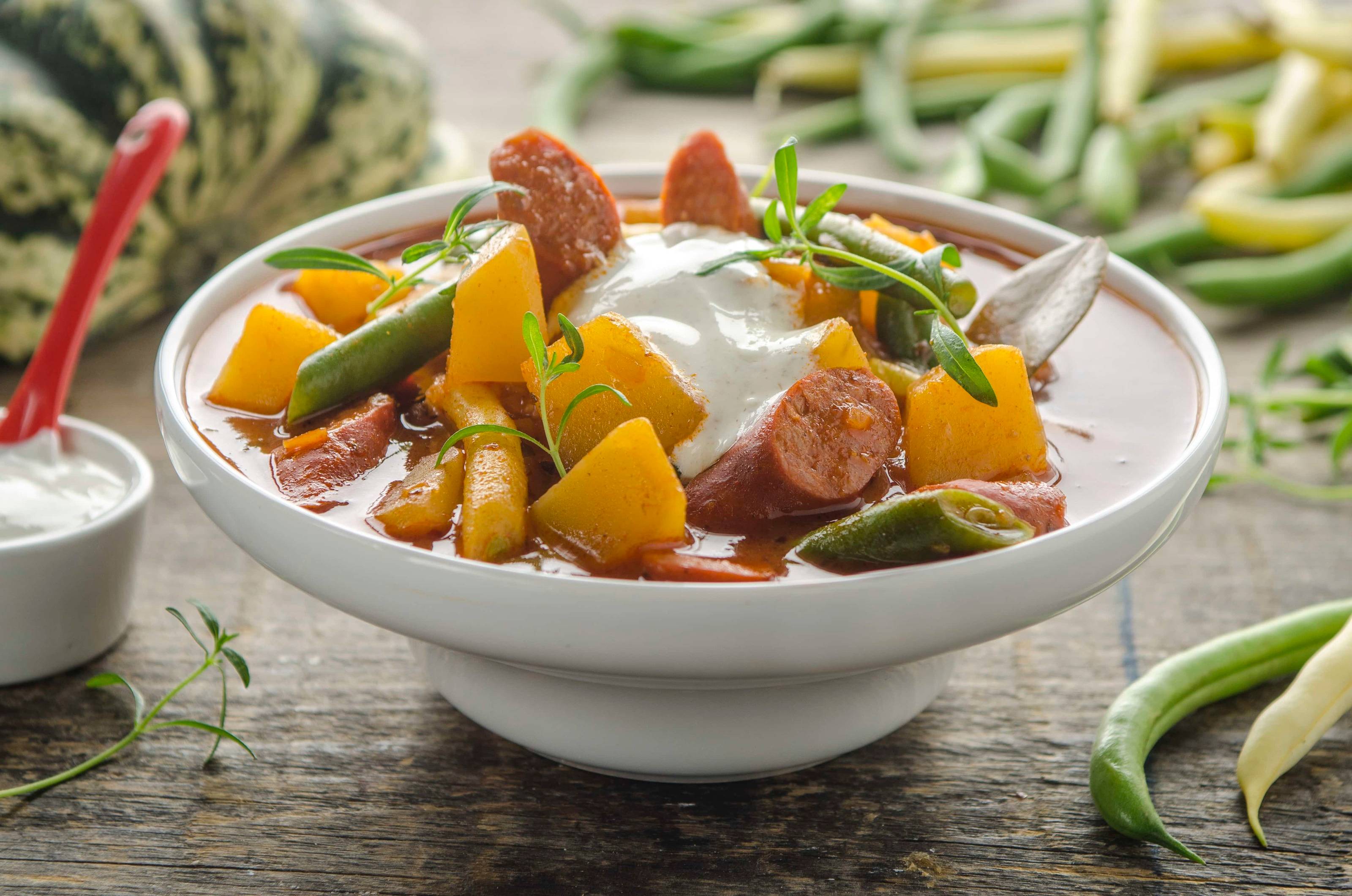 Kürbisgulasch mit Fisolen, Debrezinern und Kümmelrahm Rezept