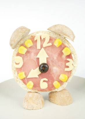 <p>Brot-Weckeruhr mit K&auml;se-Wurst-Mais-Oliven-Ziffernblatt</p>