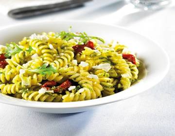 Girandole al Pesto alla Genovese mit getrockneten Tomaten, frisch geriebenem Schafskäse und Rucola