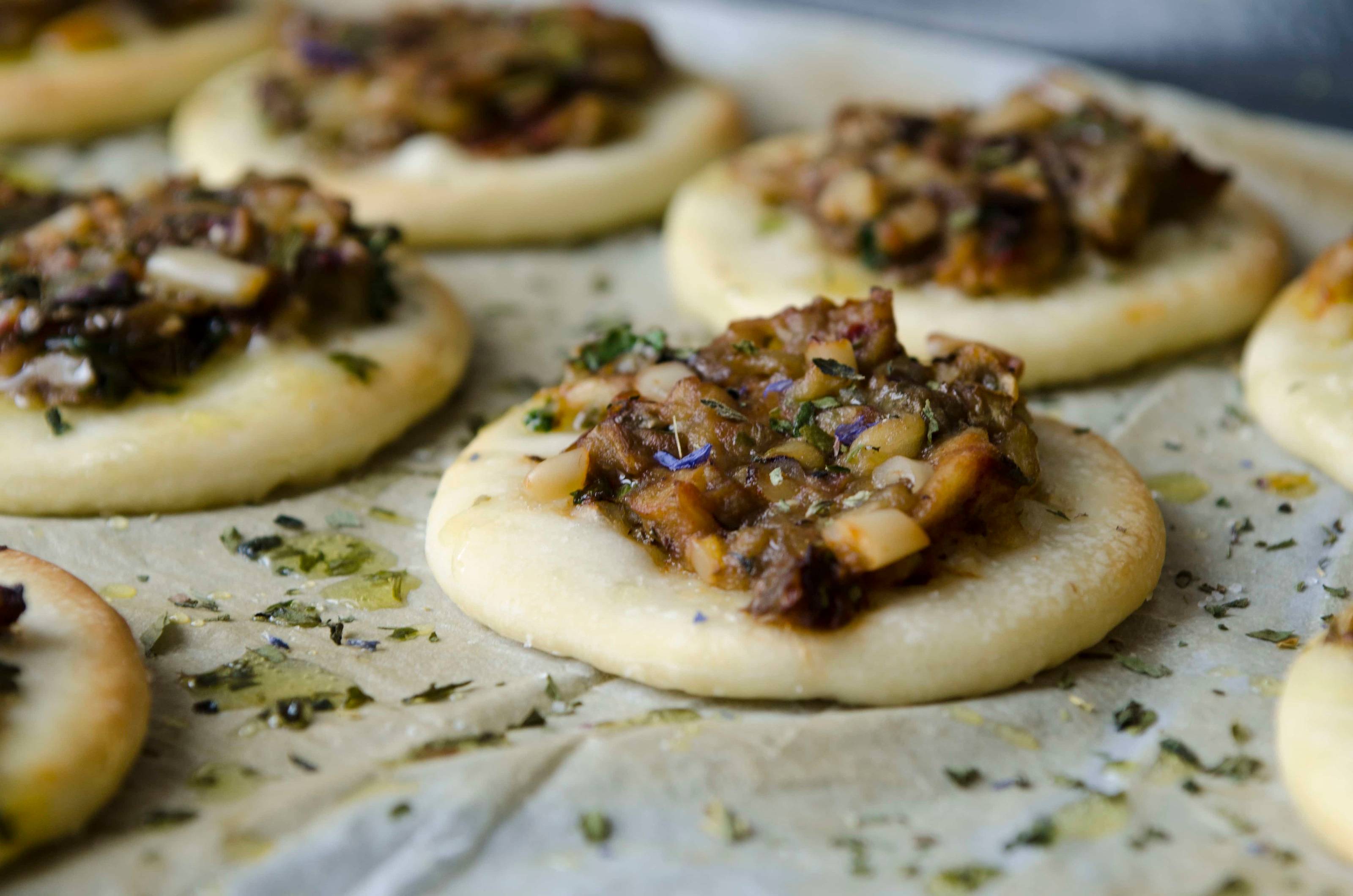 Pizzette mit Melanzani und Pinienkernen