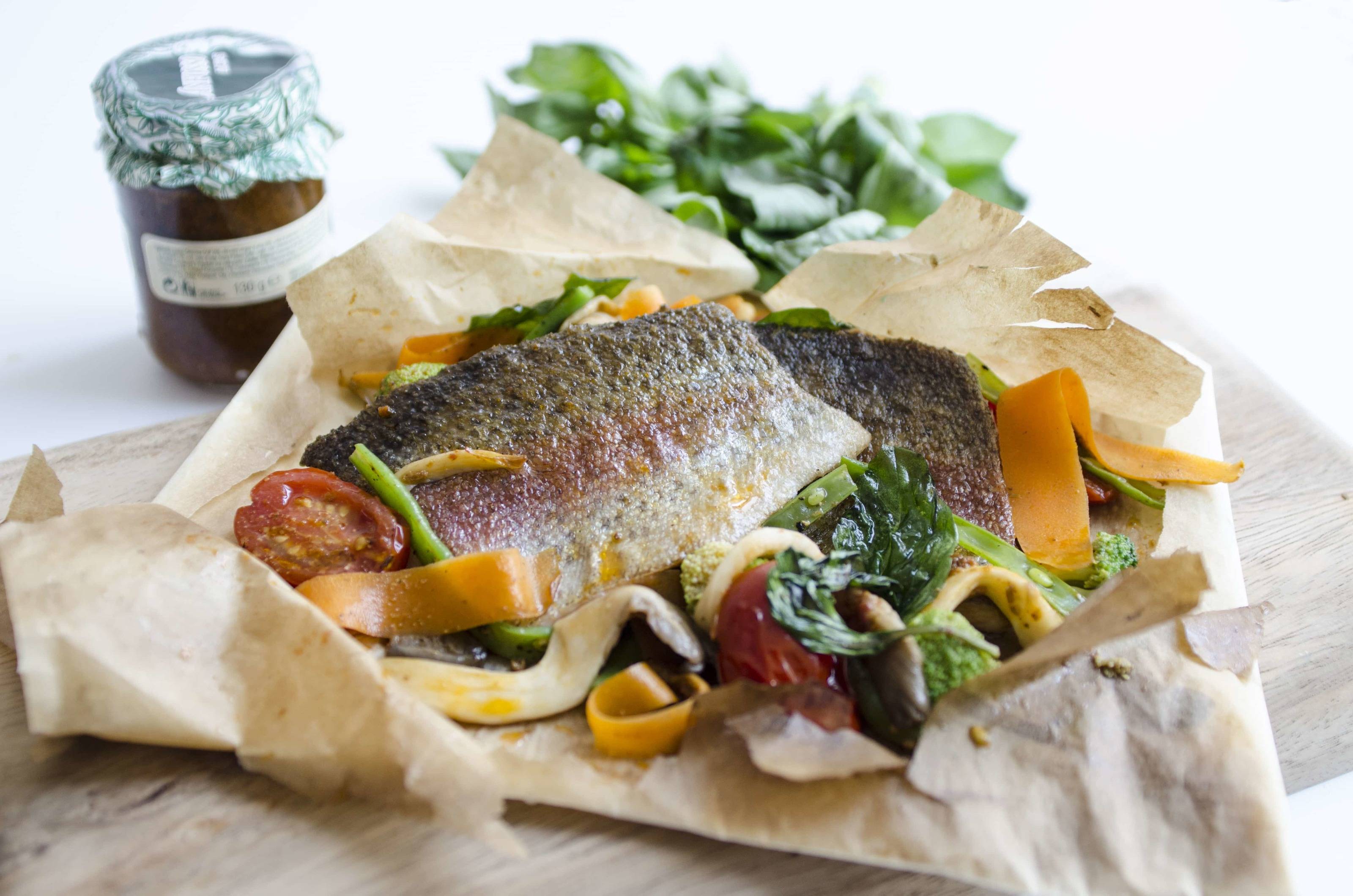 Lachsforellenfilet mit frischem Gemüse und Pinienkernen im Paket