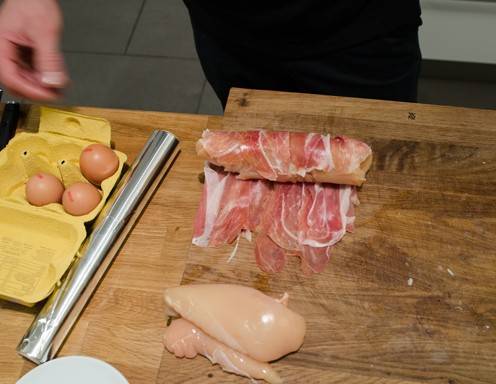 <p>Gef&uuml;llte H&uuml;hnerbrust Schritt 11 - Rollen Sie die H&uuml;hnerbrust in den Prosciutto ein.</p>