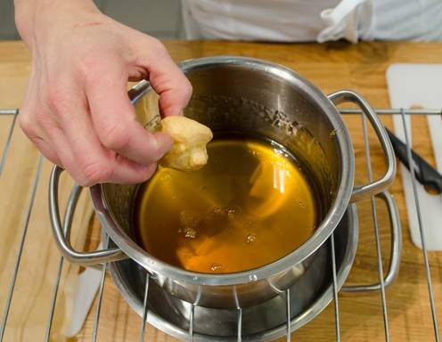 <p>Schritt 11: In einem Topf Zucker, Honig und Wasser zum Kochen bringen. Den Topf in kaltes Wasser stellen. Die Brandteigkrapferl vorsichtig mit einer Seite in den fl&uuml;ssigen Zucker tauchen (Achtung sehr hei&szlig;!!!).</p>