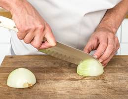 Schritt 5: Die Zwiebelhälften der Länge nach einschneiden. Den Strunk dabei nicht durchschneiden. Schritt 5: Die Zwiebelhälften der Länge nach einschneiden. Den Strunk dabei nicht durchschneiden.