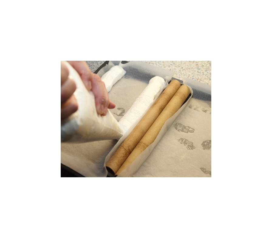 Schritt 2: 2 Streifen Backpapier (von 15 cm Breite und 40 cm Länge) getrennt von einander auf ein Backblech legen und mit der Eischneemasse beginnen.