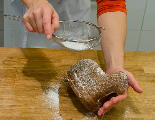 Die Schokofigur mit Staubzucker bestreuen.