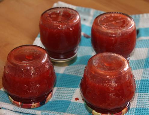 Schließen Sie nun die Marmeladengläser sorgfältig zu und stellen Sie die Gläser auf den Kopf. Achten Sie darauf, dass keine Marmeladenreste unter dem Deckel oder dem Glasrand hervorquellen bzw. wischen Sie diese gegebenfalls ordentlich weg.