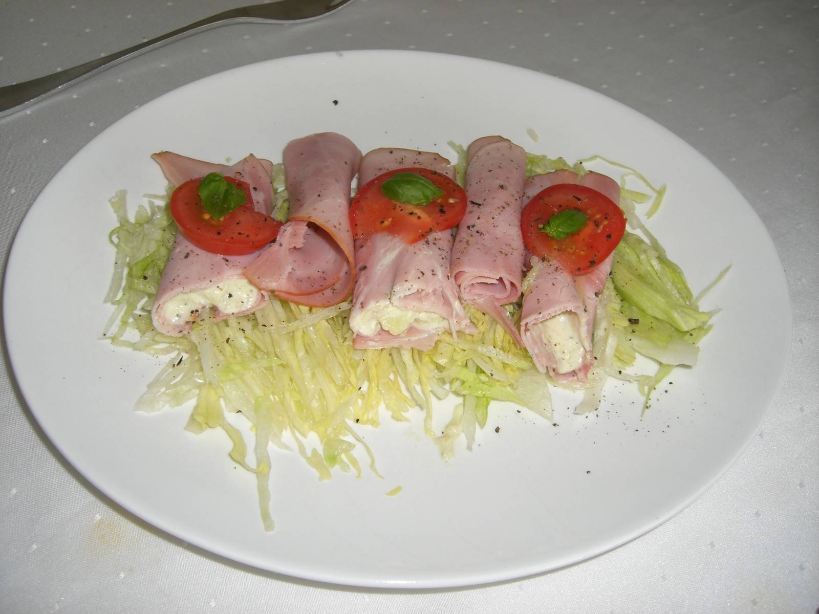 Schinkenröllchen mit Apfel und Wasabimayonnaise auf Eisbergsalat