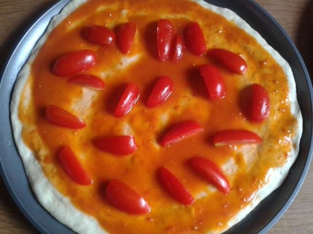 Pizza mit Cherrytomaten und Basilikum