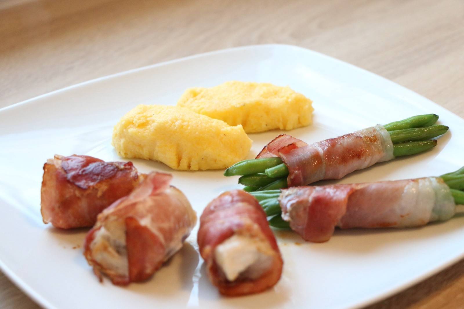 Schweinsmedaillons im Speckmantel mit Bohnen und Polenta