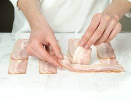 Schritt 4: Die restlichen Speckscheiben quer unter die bereits gelegten Speckbahnen einflechten. Schritt 4: Die restlichen Speckscheiben quer unter die bereits gelegten Speckbahnen einflechten.