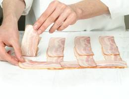 Schritt 5: Die restlichen Speckscheiben weiter quer unter die bereits gelegten Speckbahnen einflechten. Schritt 5: Die restlichen Speckscheiben weiter quer unter die bereits gelegten Speckbahnen einflechten.