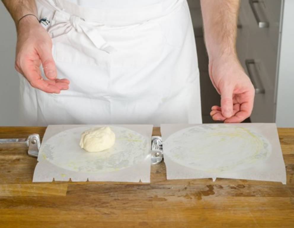 Schritt 13: Ein Teigkügelchen in die Tortillapresse legen. Schritt 13: Ein Teigkügelchen in die Tortillapresse legen.