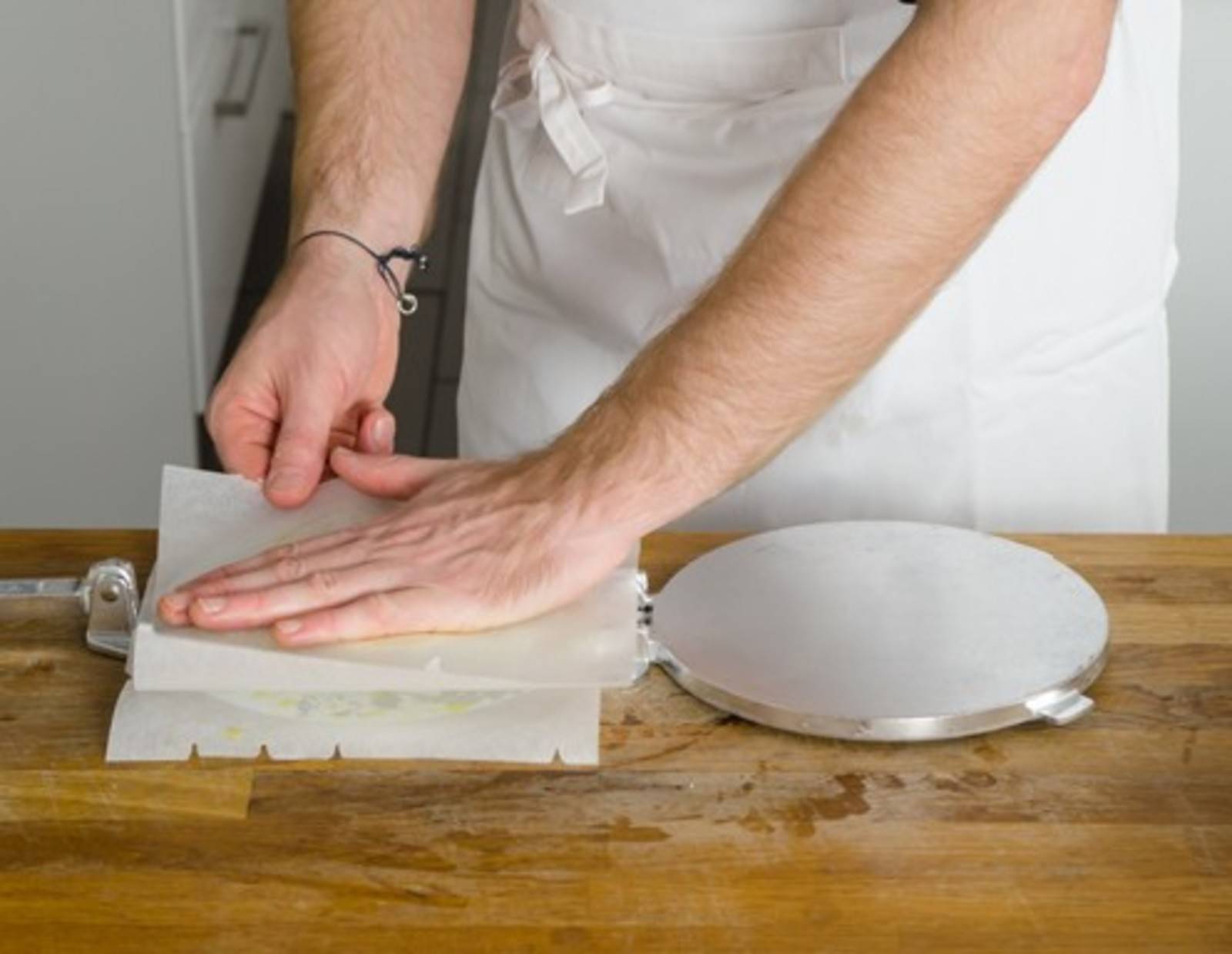 Schritt 14: Den Teig zuerst mit der Hand zwischen den beiden Backpapierblättern flach drücken.